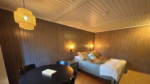A room with a bed, a table, and two wall-mounted lamps. - Tankavaara Gold Village (Sodankyla)
