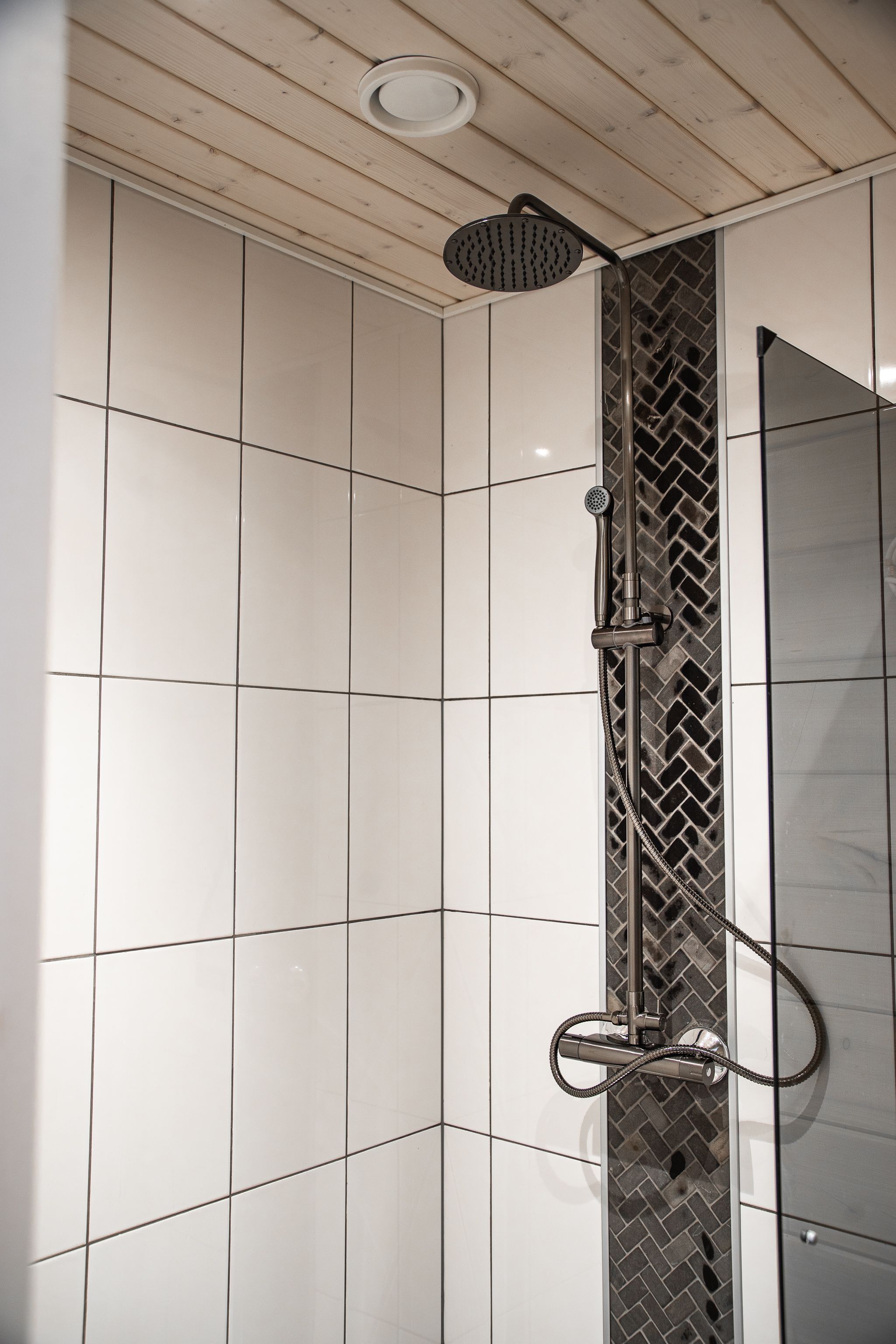 A shower with a modern design, featuring a rain shower head and a handheld shower attachment.