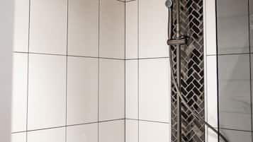 A shower with a modern design, featuring a rain shower head and a handheld shower attachment.