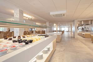 A modern hotel dining area with a buffet setup, marble columns, and a spacious layout. - Hotel Best Delta (Llucmajor)