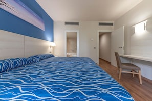Une chambre avec un grand lit, un bureau et une chaise.