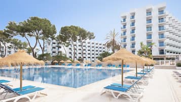 Alberca techada, alberca al aire libre y sombrillas en la alberca