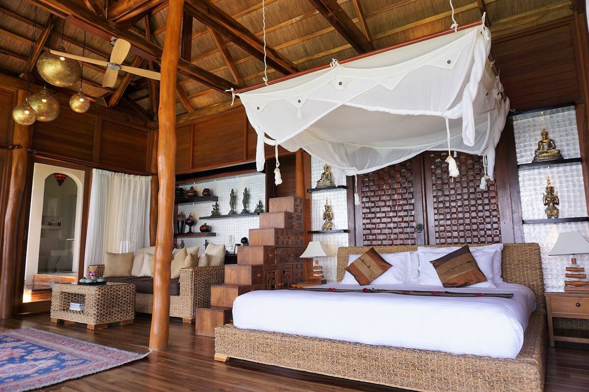 A spacious room with a large bed, wooden furniture, and a canopy bed.