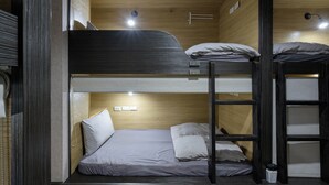A bunk bed room with a wooden ceiling, a ladder, and a small trash bin. - Work Inn TPE - Hostel (Taipei)