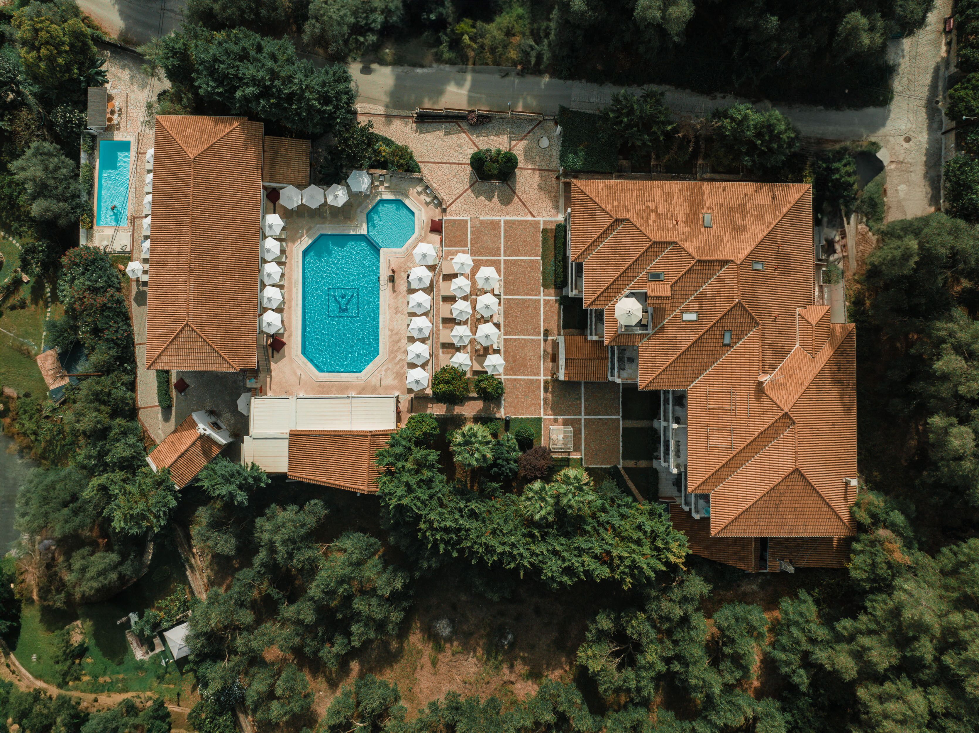 Vista aèria d'una propietat amb piscina, zona d'estar exterior i terrassa coberta.