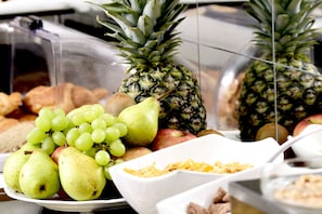 A buffet with a variety of fruits including grapes, pears, apples, and pineapples. - Hotel Altera Pars (Cologne)
