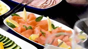 A buffet table with various dishes including smoked salmon, lemon slices, and vegetables. - Hotel Altera Pars (Cologne)