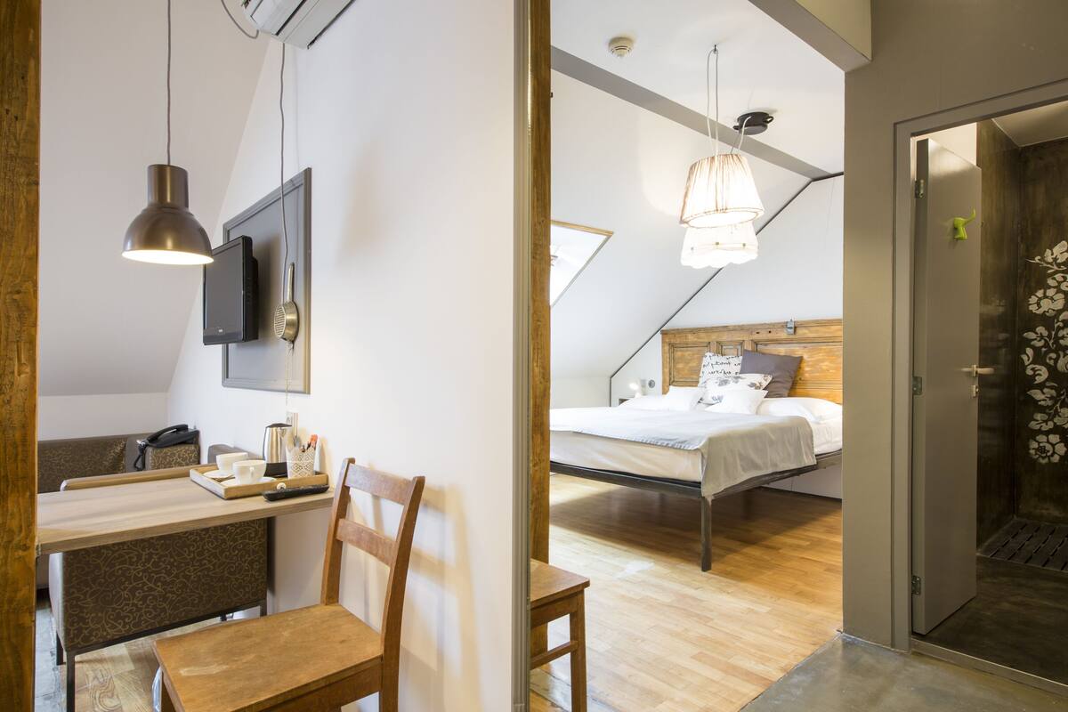 Een moderne slaapkamer met een houten hoofdeinde, een nachtkastje en een hanglamp.