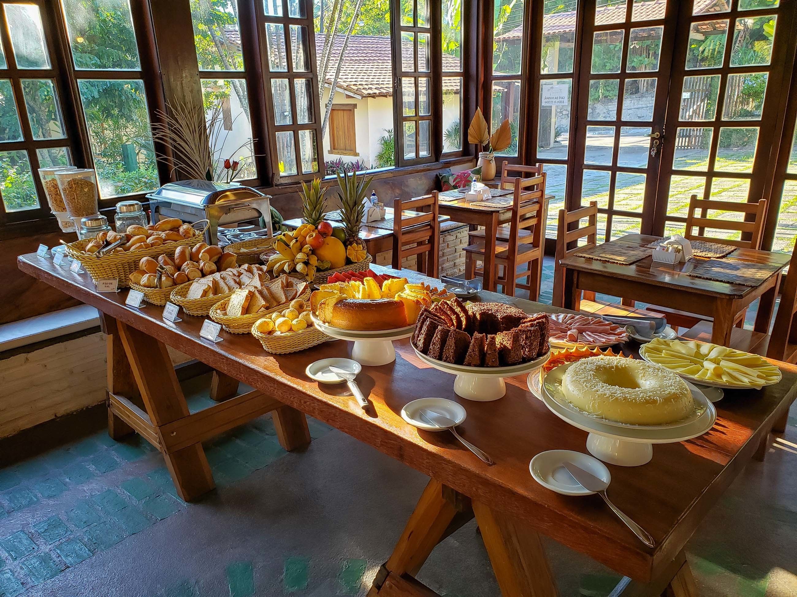 Een buffet met diverse gerechten en uitzicht op het omliggende landschap door grote ramen.