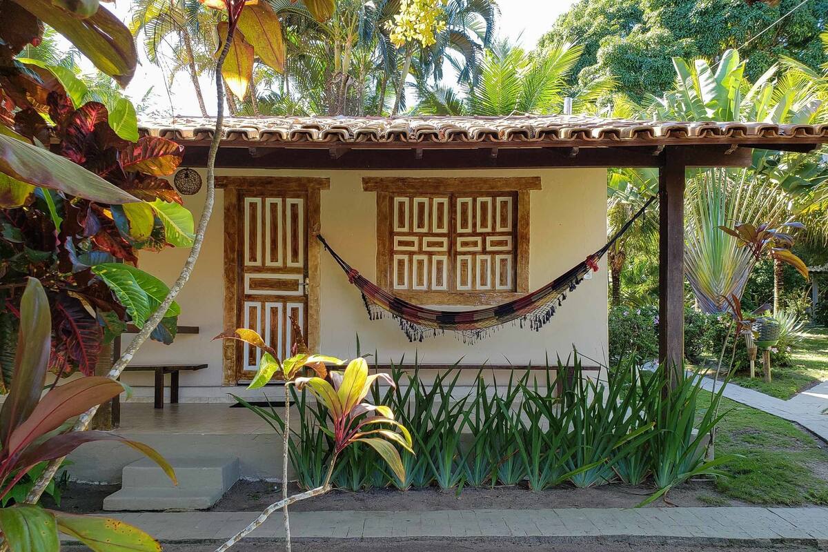 A small building with a tiled roof, two wooden doors, and a hammock.