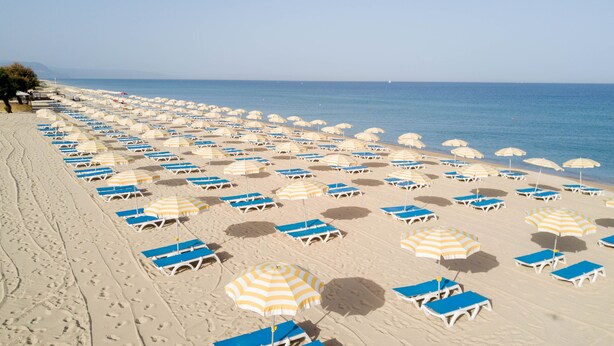 A beach with rows of sun loungers and striped umbrellas. - Nicotera Beach Village (Nicotera Marina)