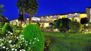 A hotel with multiple buildings, well-lit balconies, and manicured gardens. - Nicotera Beach Village (Nicotera Marina)