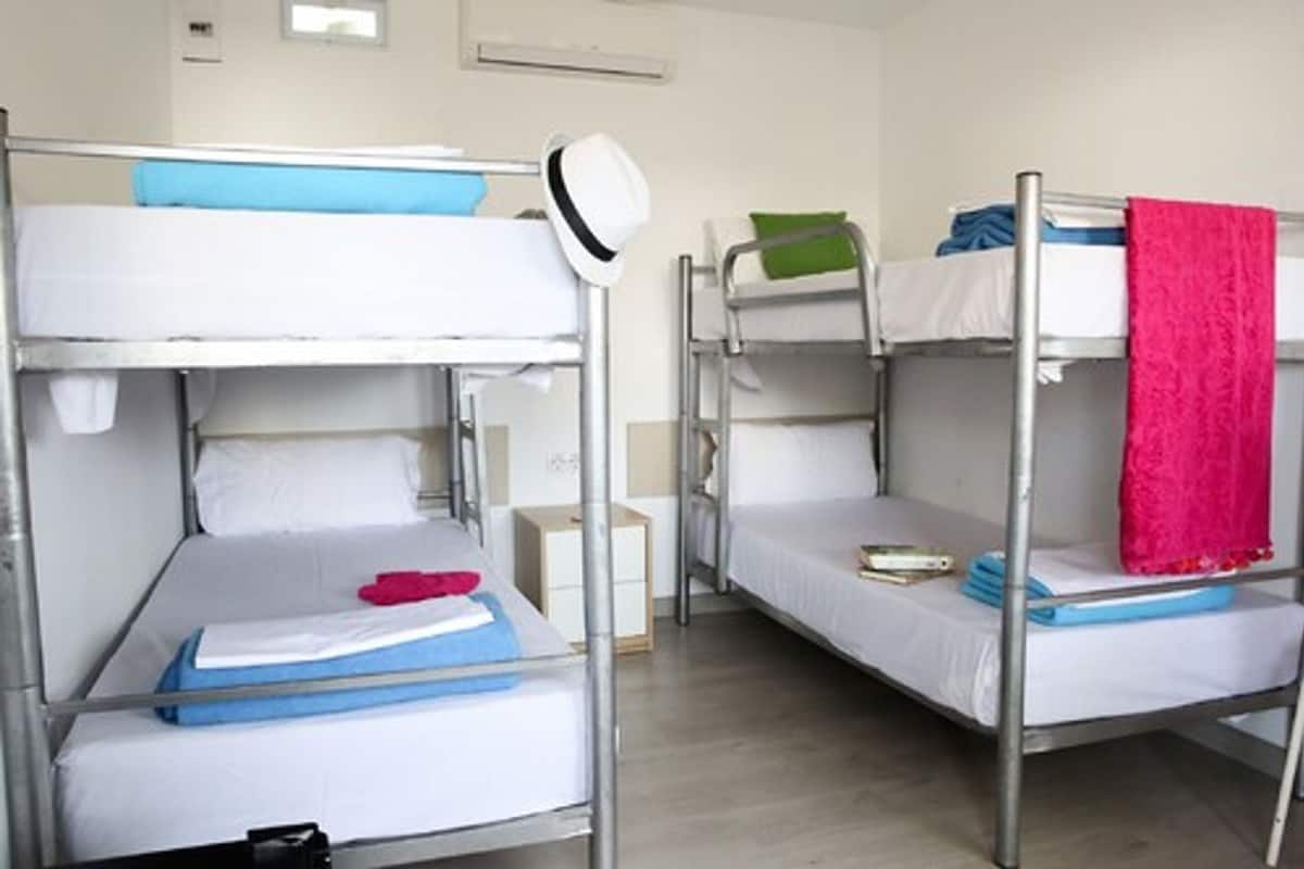 Quarto com beliche, duas camas, cada uma com travesseiro e cobertor.