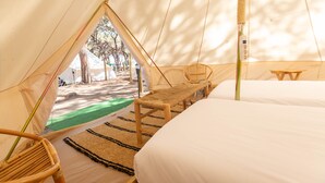 A tented accommodation with a bed, a bench, and a chair. - Camping 3 Estrellas (Gava)