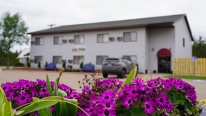 A building with a flat roof, multiple windows, and a signboard. - Model Towne Inn (Gwinn)