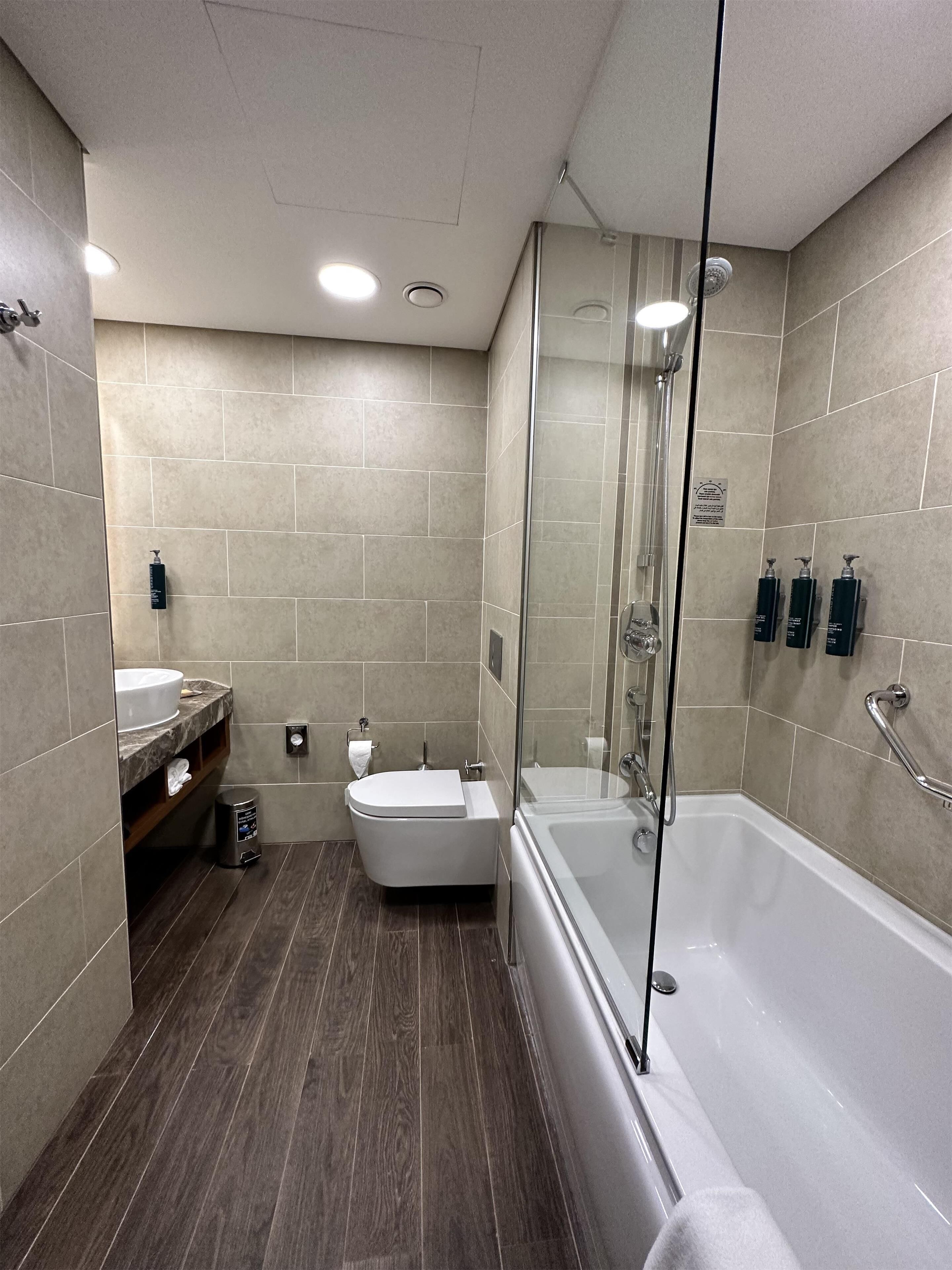 A modern bathroom with a bathtub, toilet, and sink.