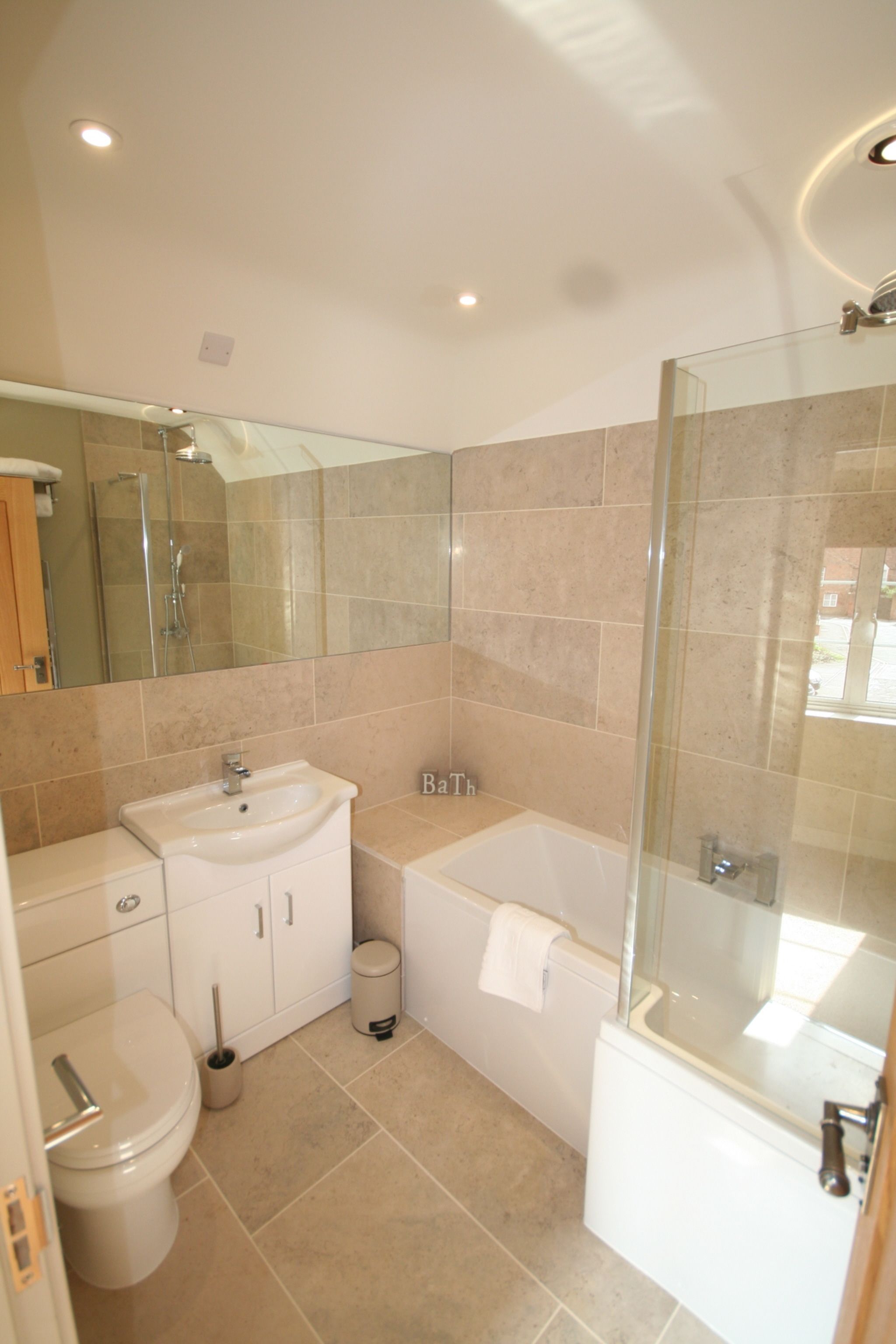 A modern bathroom with a glass-enclosed shower, a white sink, and a toilet.