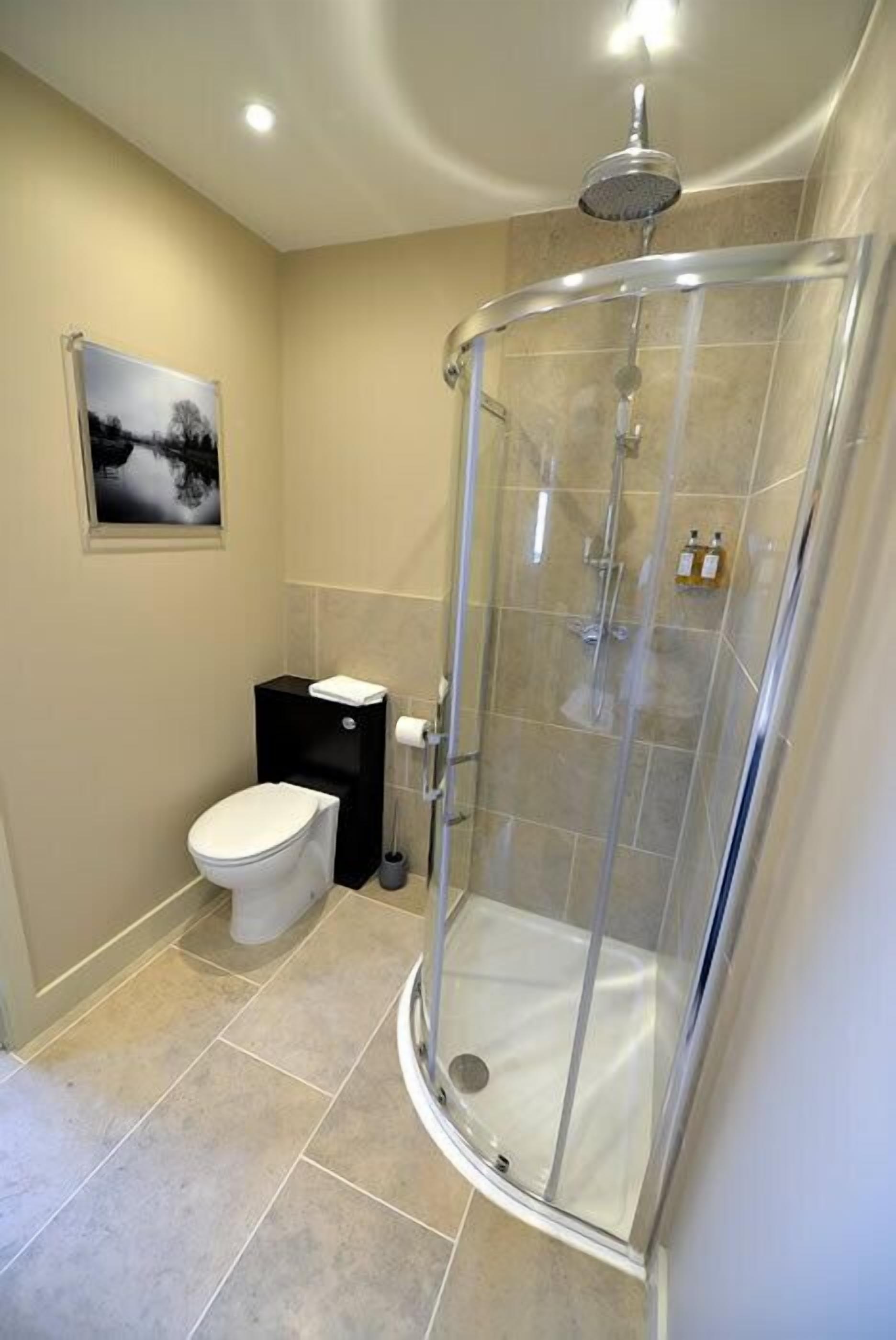 Une salle de bain moderne avec une douche à parois de verre, des toilettes et un lavabo.
