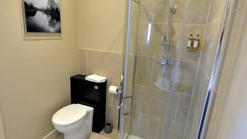 Une salle de bain moderne avec une douche à parois de verre, des toilettes et un lavabo.