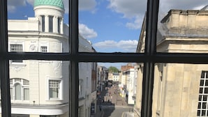 A street view through a window with a building featuring a green dome and a sign for St. John's Street. - The Peppermill (Devizes)