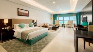 Habitació d'hotel moderna amb un llit gran, un escriptori, una cadira i vistes a l'oceà.