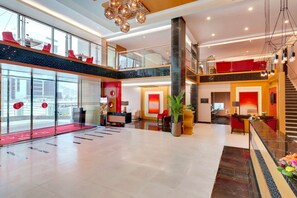 A spacious lobby with a reception desk, seating area, and a staircase leading to upper floors. - Ramada Hotel & Suites by Wyndham Amwaj Islands Manama (Amwaj Islands)