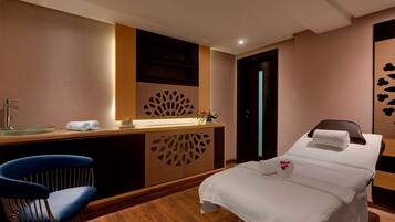 Relax in a stylish room with a made bed, comfortable chair, and modern vanity.