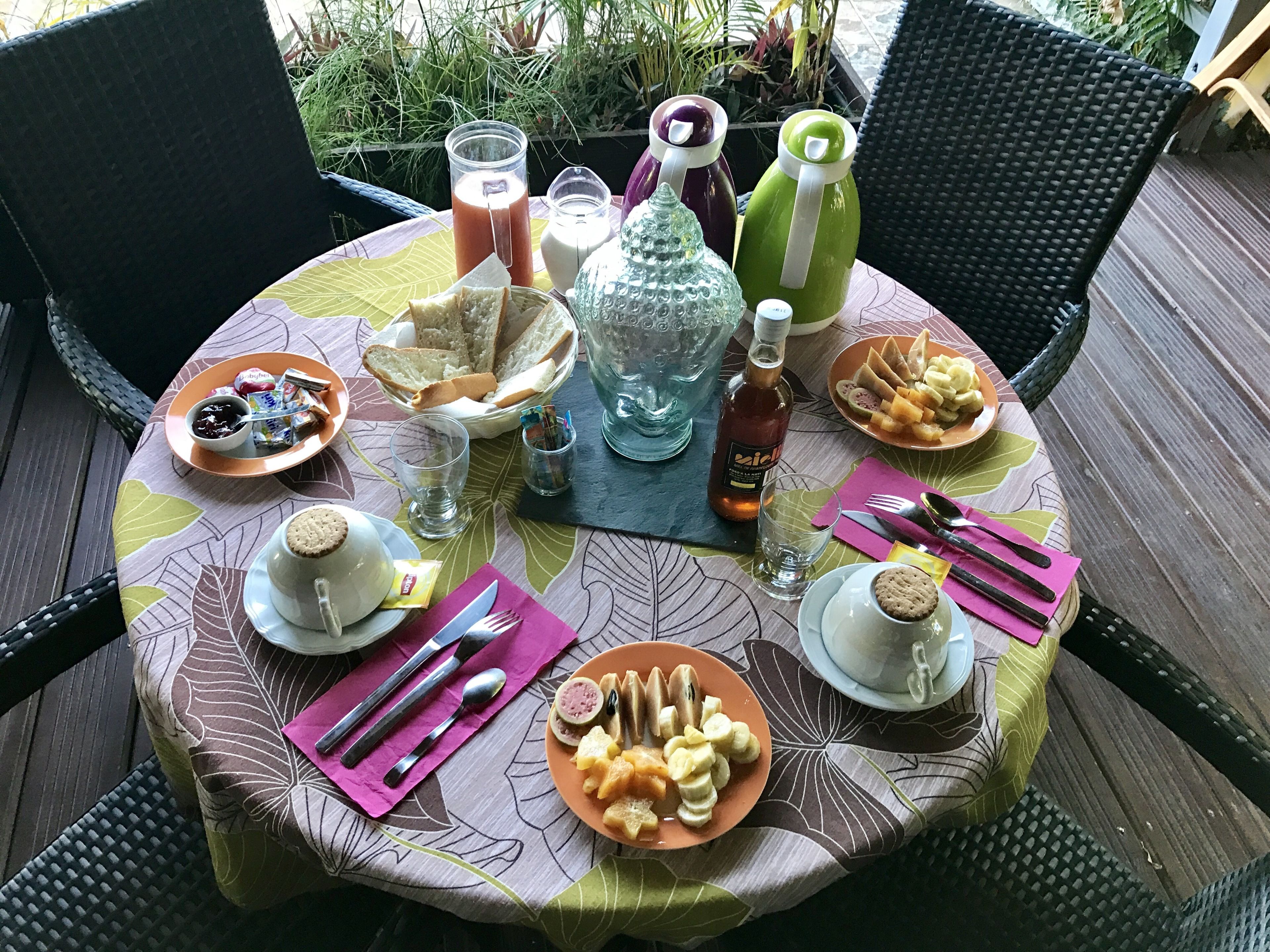 Een ronde tafel met diverse gerechten, drankjes en bestek.