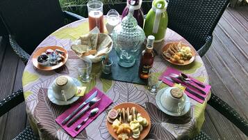 Una mesa redonda con diversos alimentos, bebidas y utensilios.