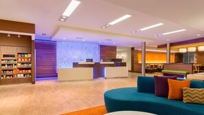 A modern hotel lobby with a reception desk, seating area, and a snack bar. - Fairfield Inn & Suites Pittsburgh Airport/Robinson Township (Pittsburgh)
