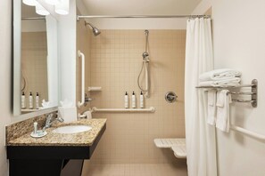 A bathroom with a sink, mirror, shower, and towel rack. - TownePlace Suites Minneapolis near Mall of America (Bloomington)