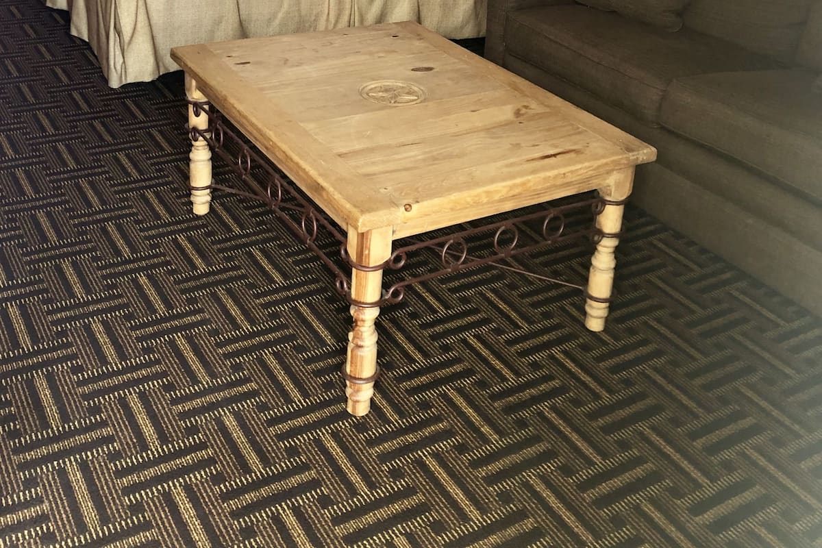 Ein Hotelzimmer mit einem Bett, einem Holztisch, einer Couch und zwei Lampen.