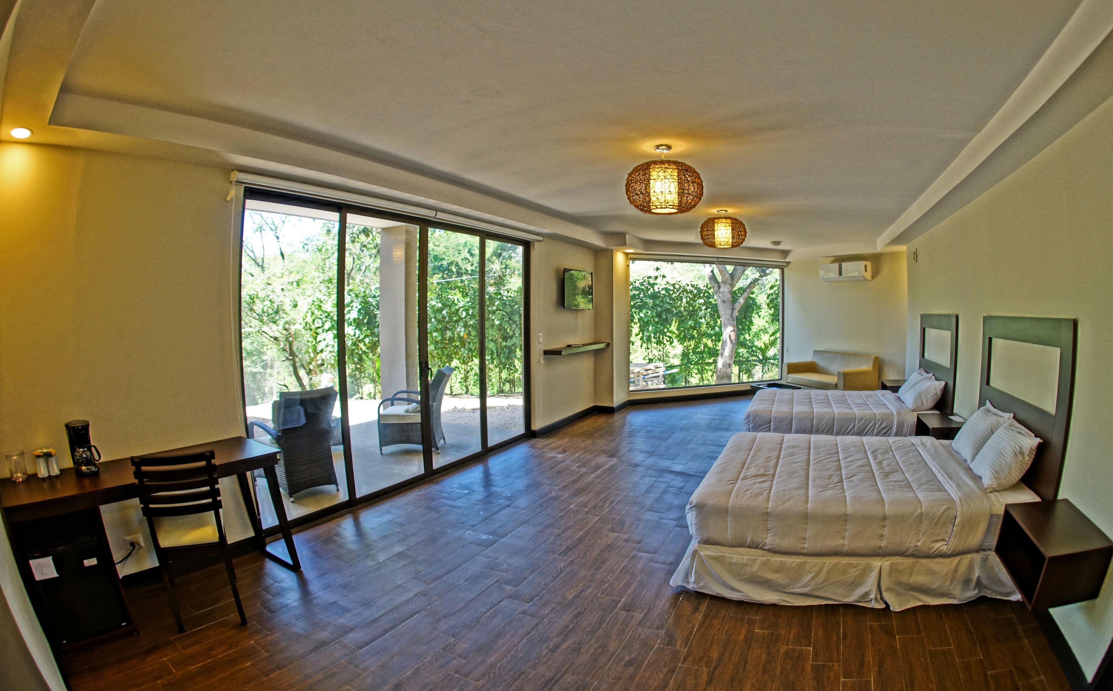 Un dormitorio amplio con dos camas, un escritorio y una silla.