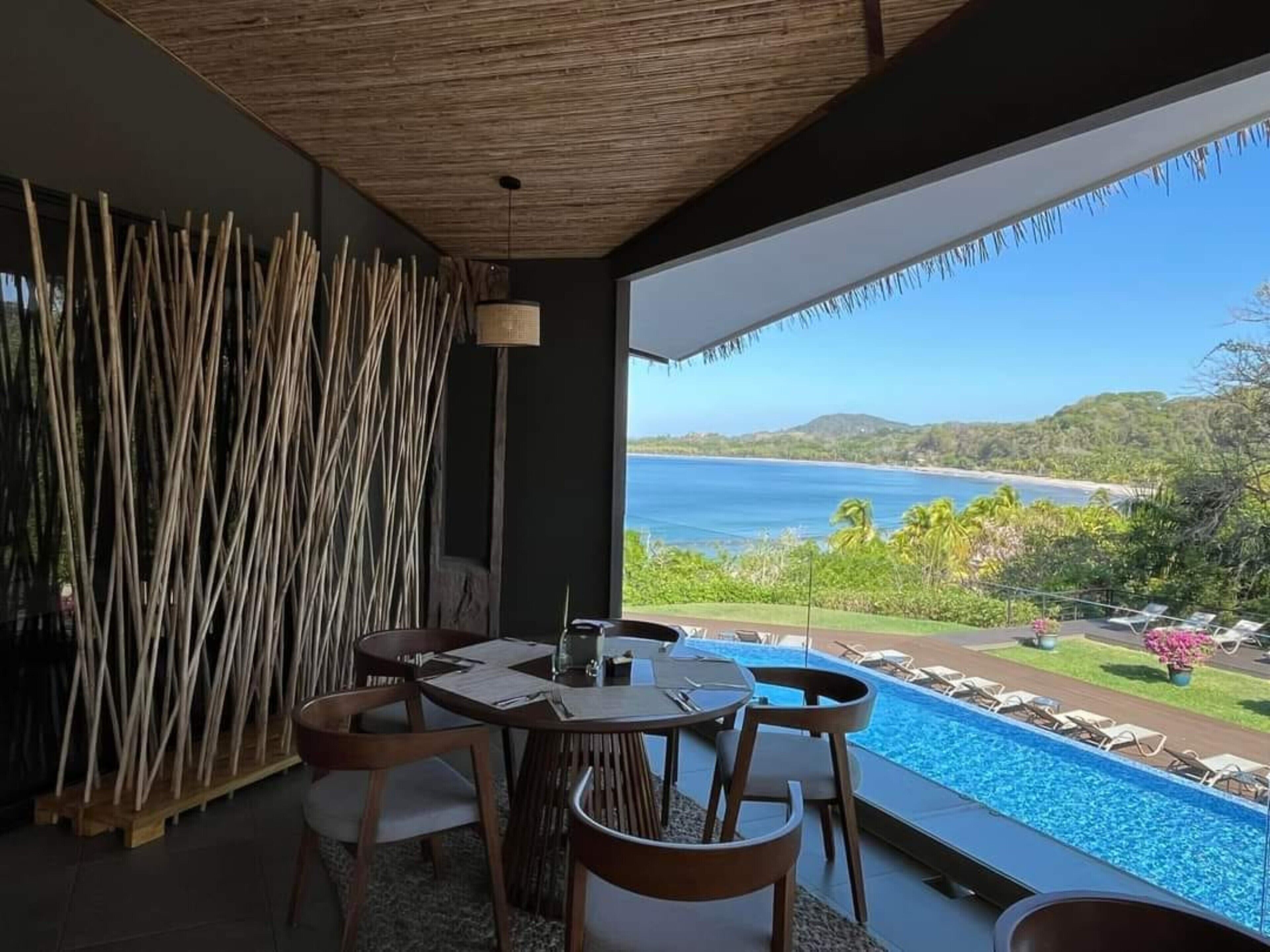 En matplats med utsikt över havet och en pool.