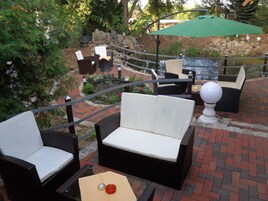 An outdoor seating area with wicker furniture and a small table with a candle.