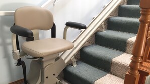 Una escalera con acceso para sillas de ruedas, barandilla y plataforma en cada escalón.