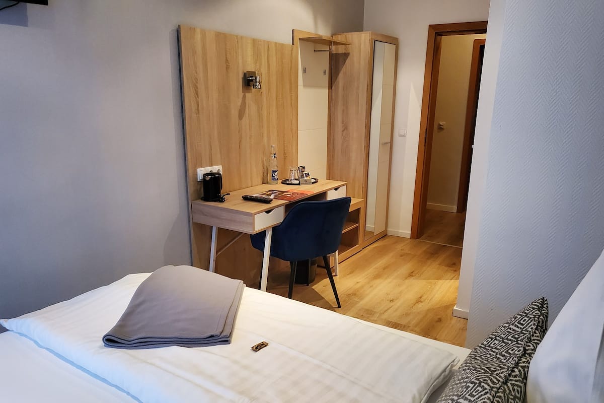 Quarto com uma cama, uma escrivaninha e uma cadeira.