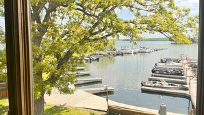 A view of a docked marina with boats and a large tree in the foreground. - Horseshoe Bay Lodge (Walker)