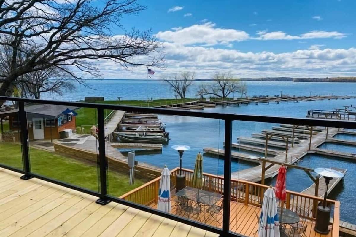 A deck with a view of a marina and docked boats.