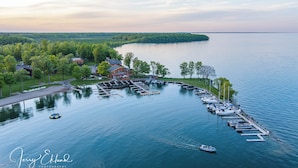 A marina with boats docked, a dock extending into the water, and a building with a red roof. - Horseshoe Bay Lodge (Walker)