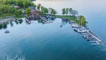 A marina with boats docked, a building with a dock, and a lake.