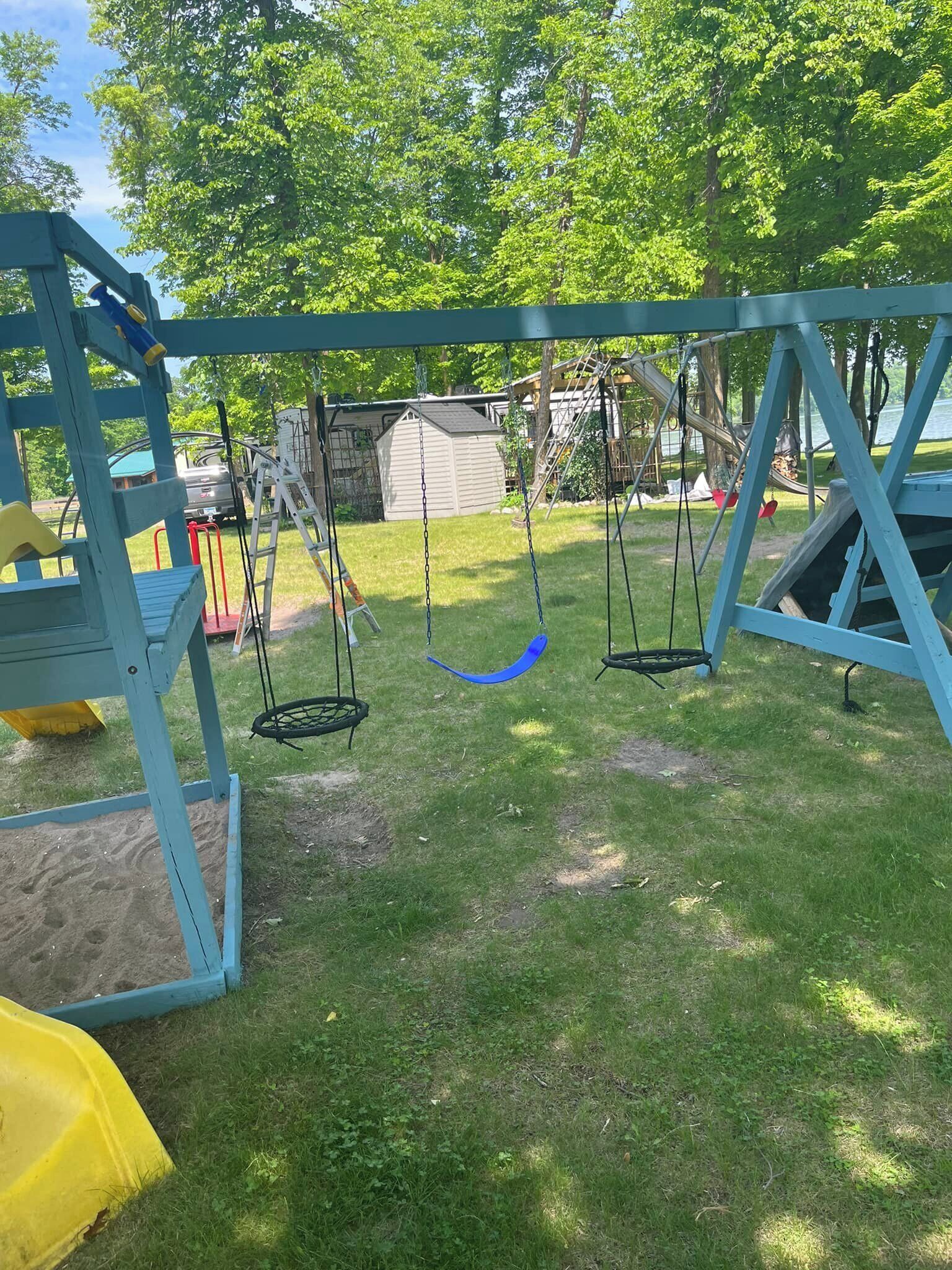 Une aire de jeux avec des balançoires et un toboggan.