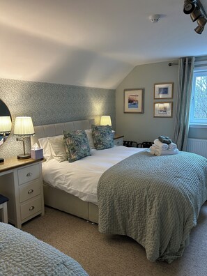 A neatly arranged bedroom with a bed, bedside tables, and a window with curtains. - Castlecroft (Stirling)