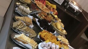 A buffet with various food items including meats, cheeses, and fruits.