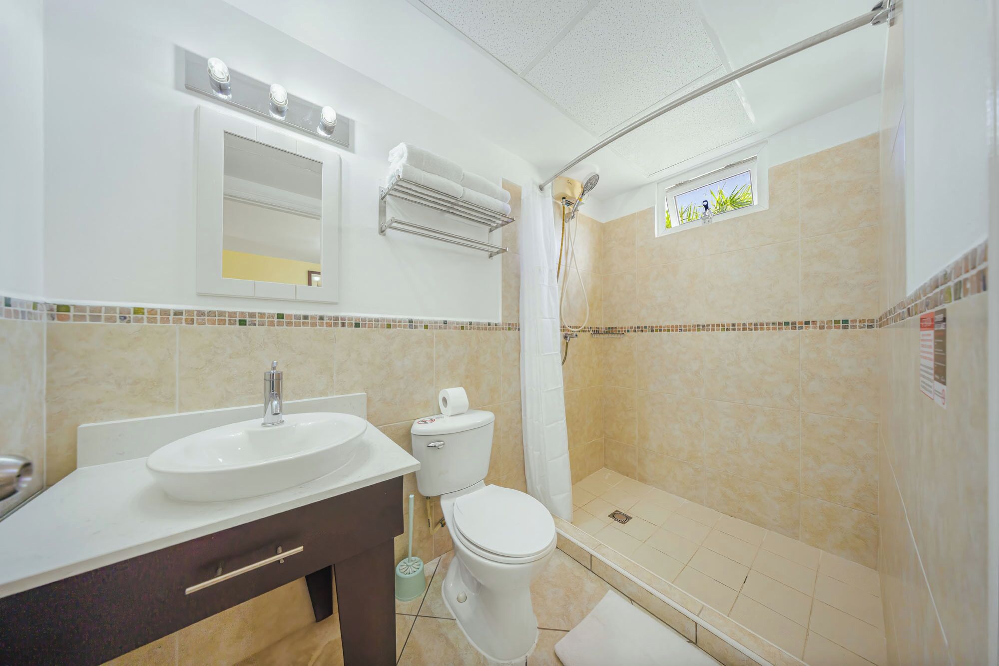 Un baño con lavamanos, inodoro y ducha.
