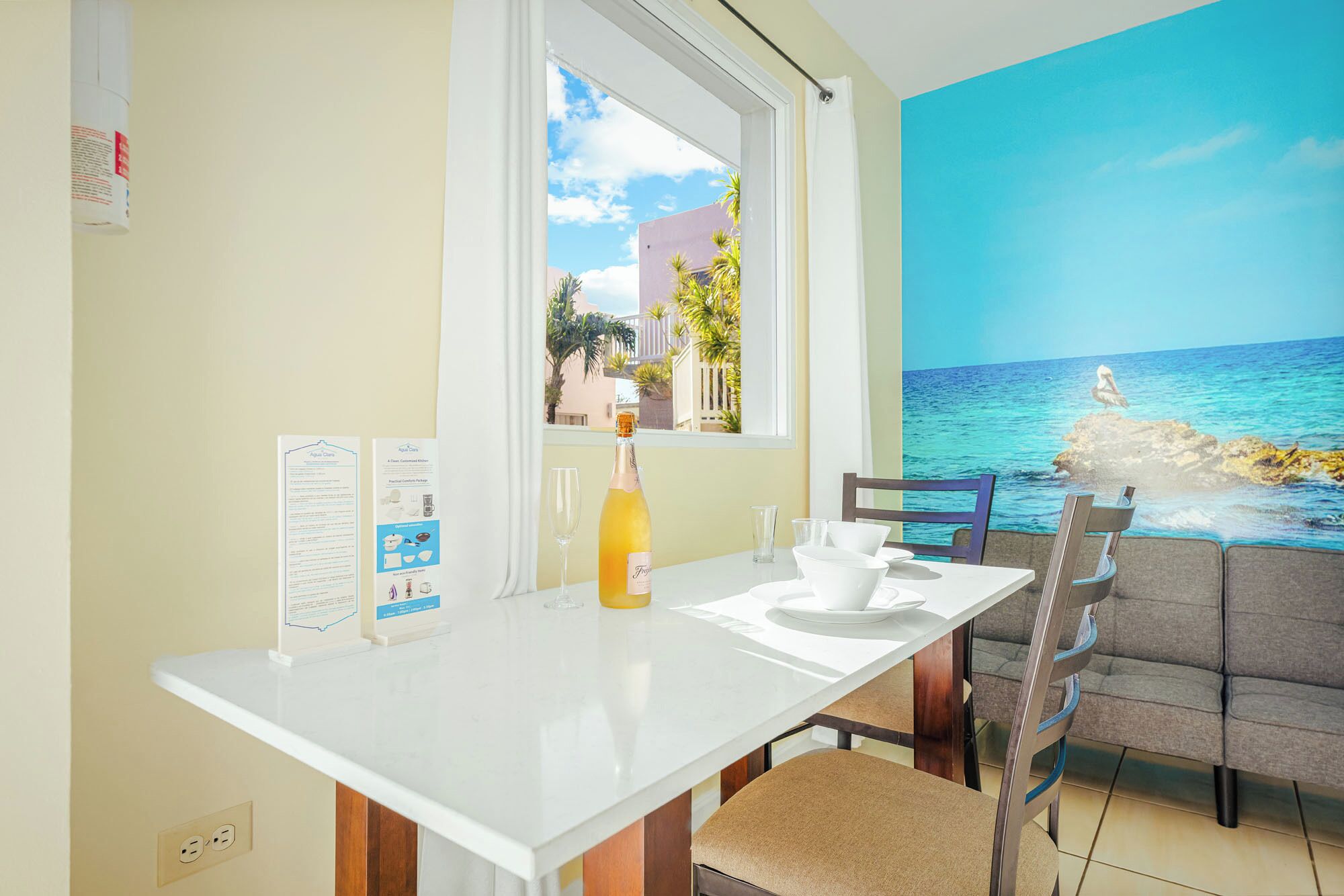 A dining area with a table, chairs, a bottle of champagne, and a menu stand.