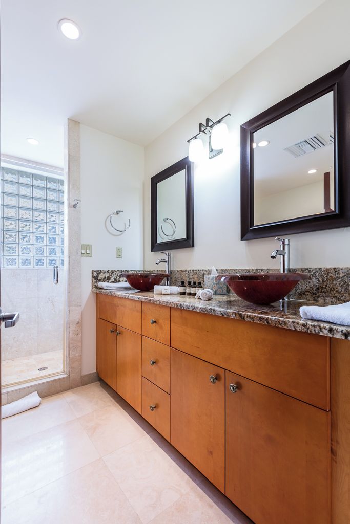 Un baño con dos lavamanos, un espejo grande y una zona de ducha.