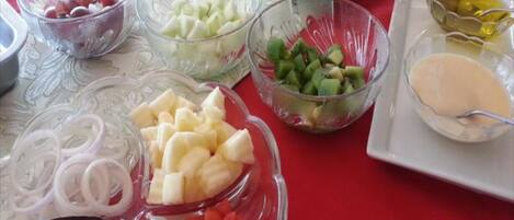 A table with various food items including fruits, vegetables, and condiments.