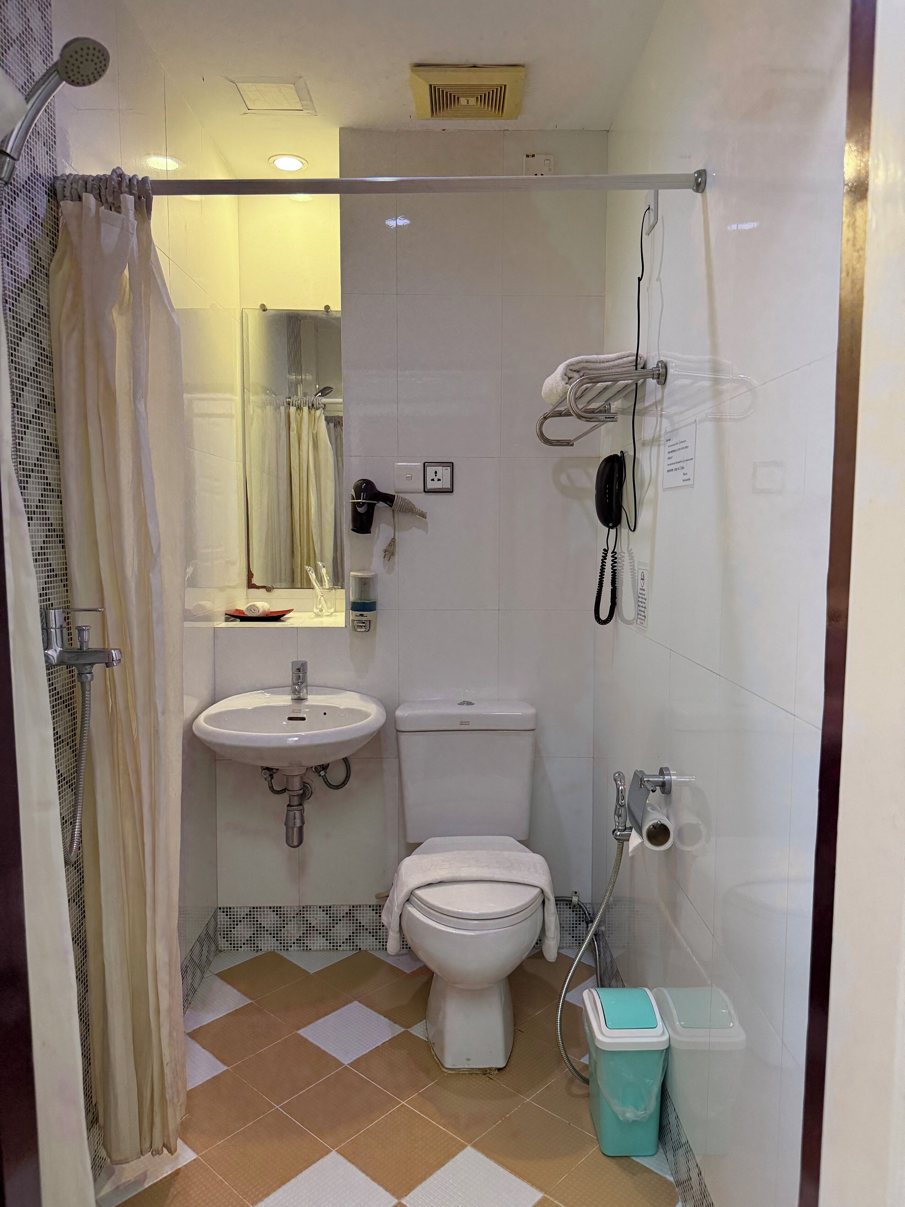 Un baño pequeño con inodoro, lavamanos y ducha.