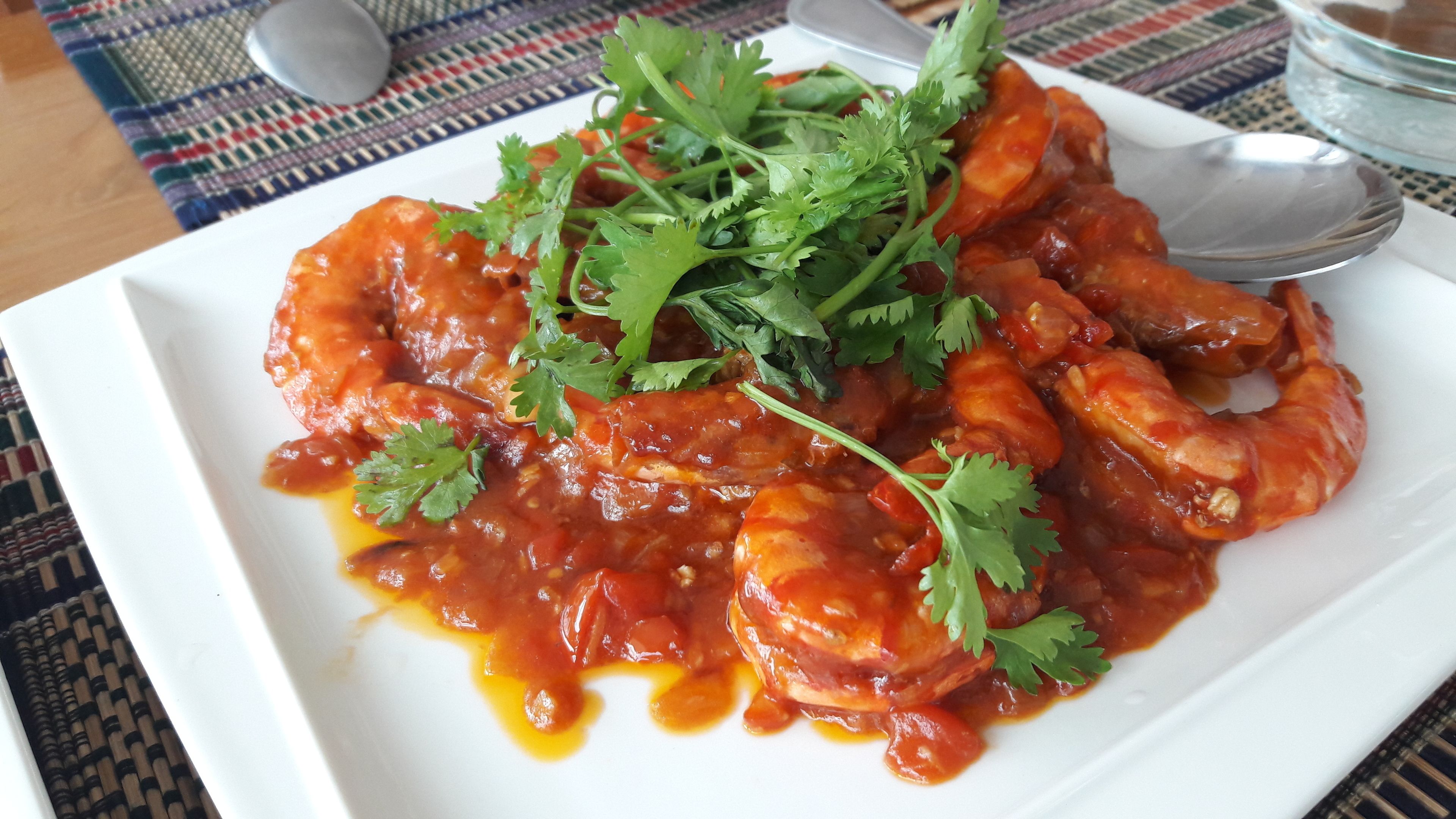 Un plato de comida con salsa roja y adorno de cilantro.